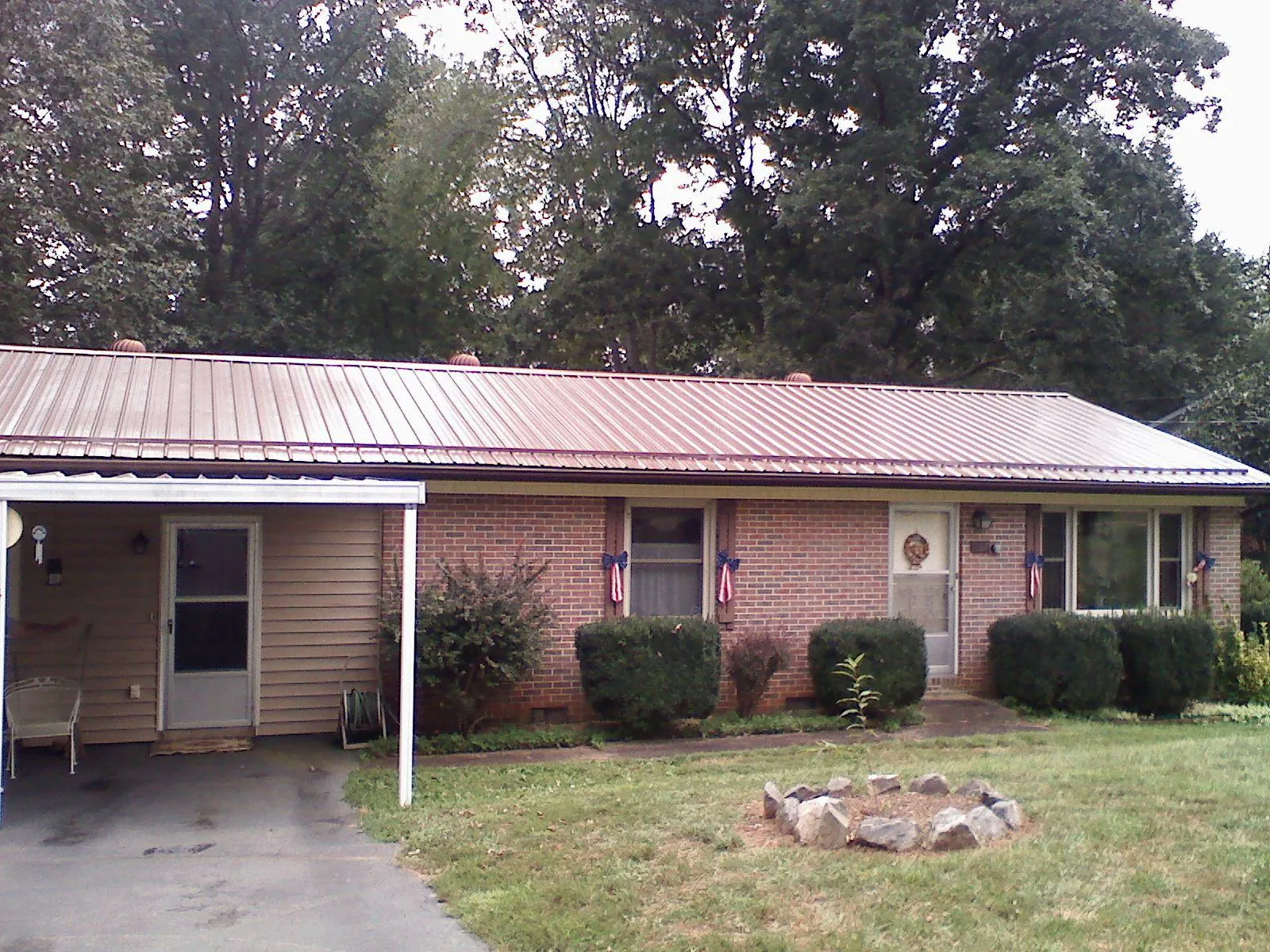 Bronze metal roof and carport on a brick ranch home — Roof Repair work by our crew in Glen